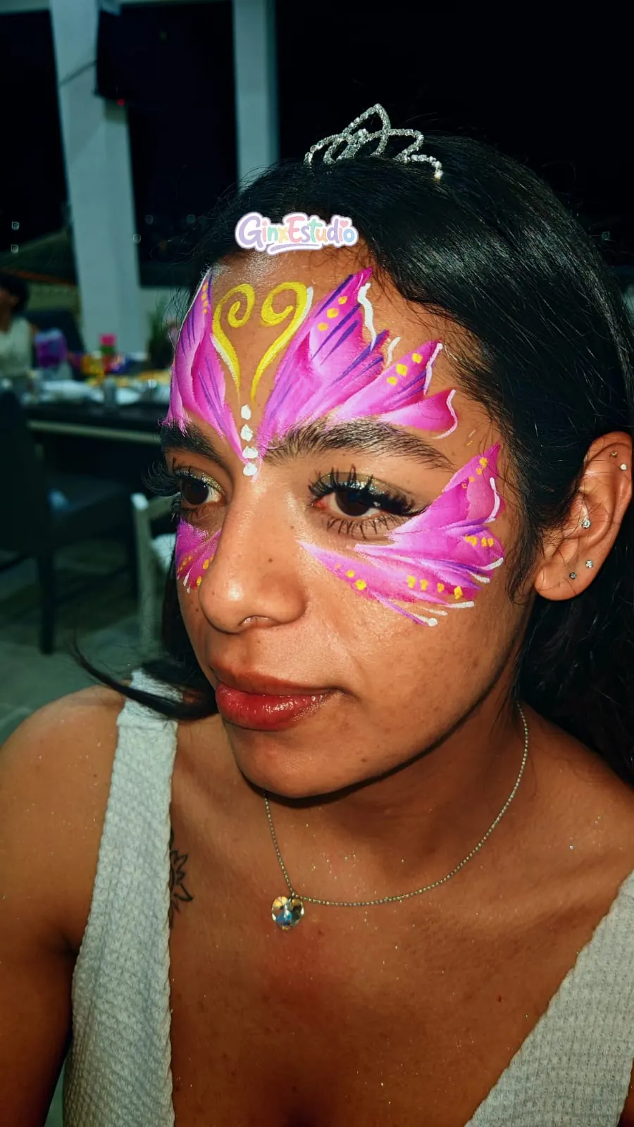 Antifaz de mariposa rosa con tiara pintado en la cara