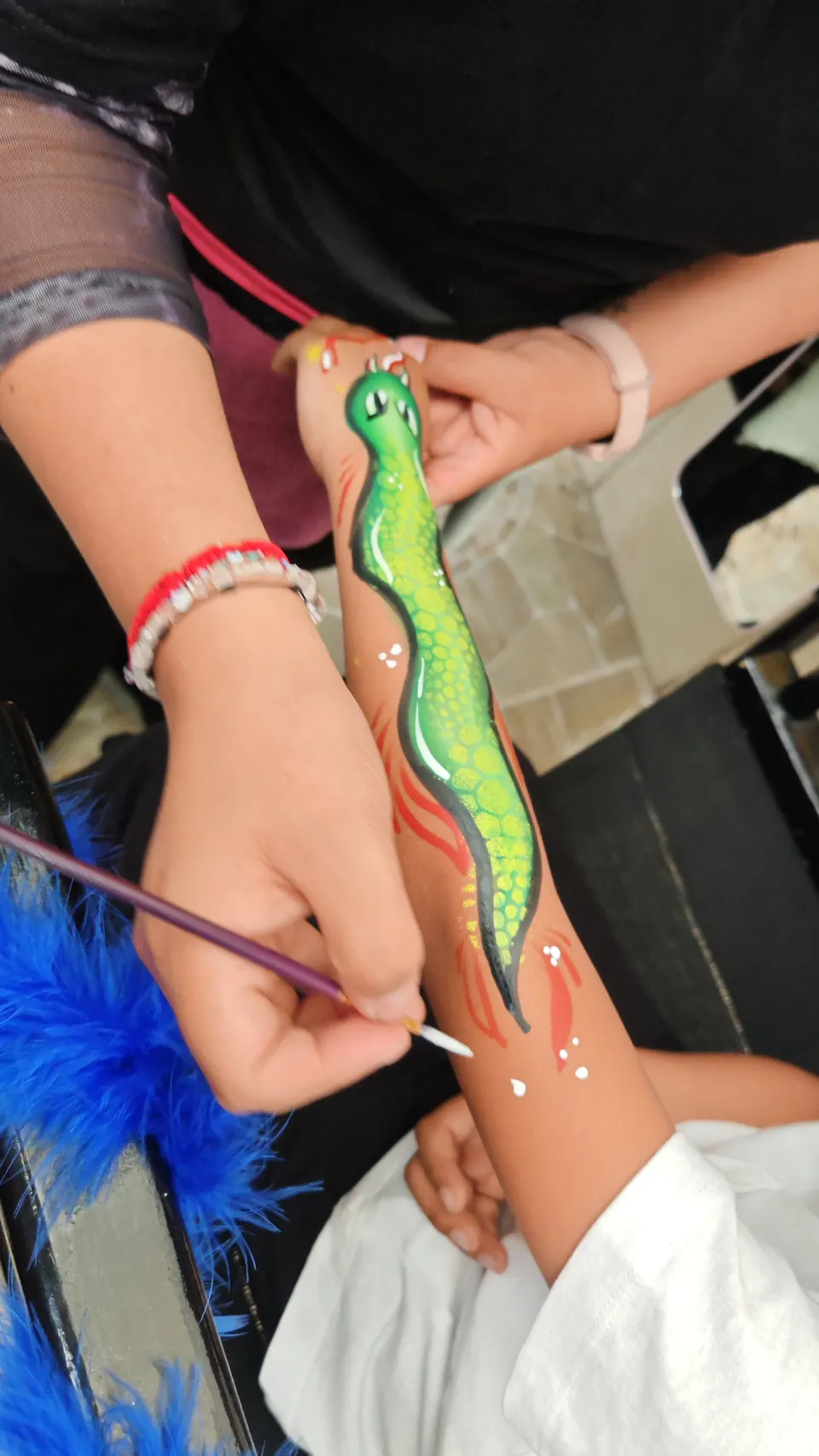 Serpiente verde pintada en el brazo de un niño