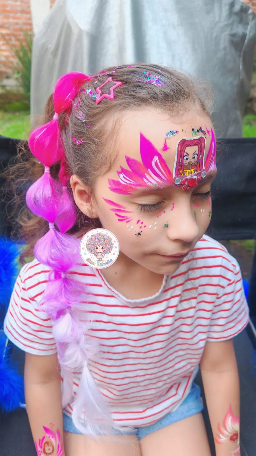 Niña con corona rosa pintada y trenzas con extensiones de colores