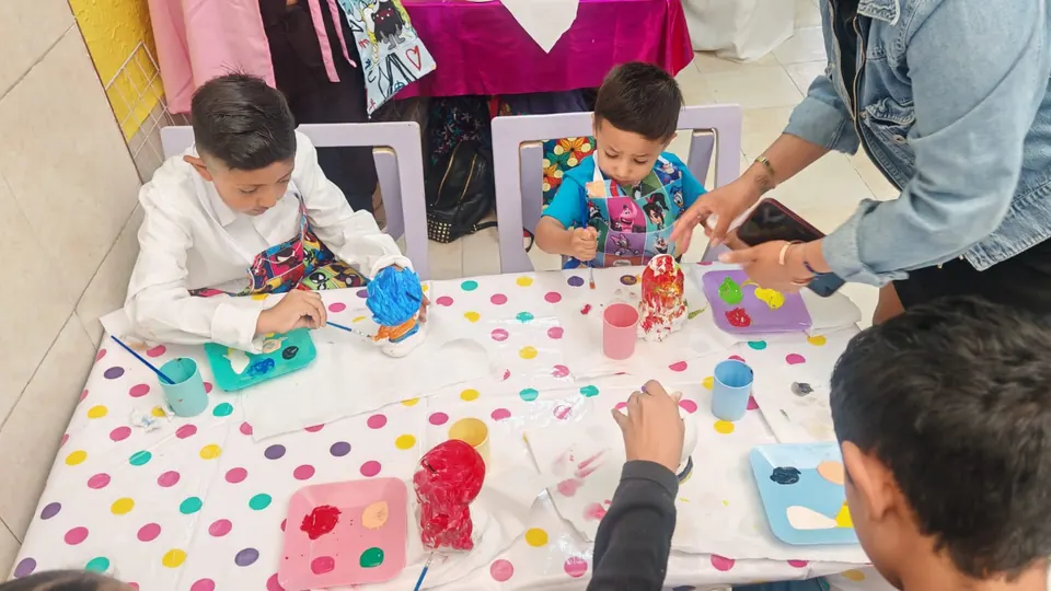 Mesa de lunares del taller pinta yesitos con peques pintando